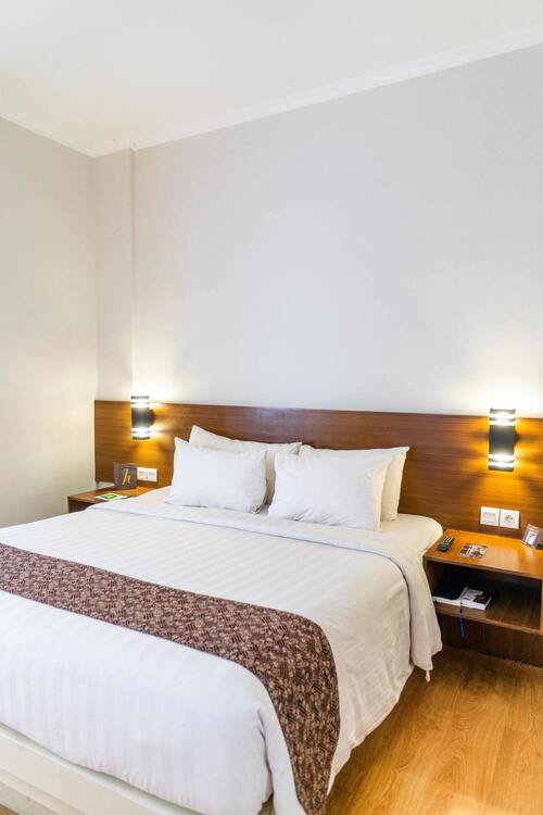 Chambre avec un lit et deux tables de nuits.